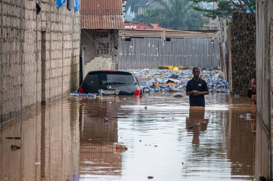 Un habitant patauge dans des eaux troubles la suite de fortes pluies dans le quartier de Ndjili à Kinshasa, le 6 avril 2025. © Hardy BOPE / AFP