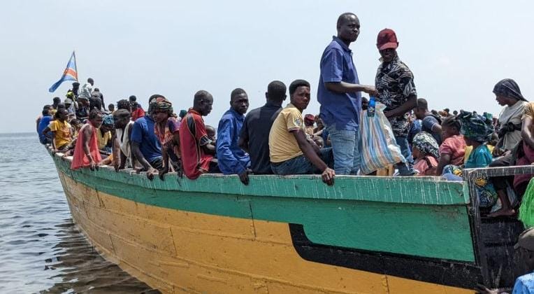 Photo prise sur le lac Albert dans une pirogue complètement chargé des personnes.