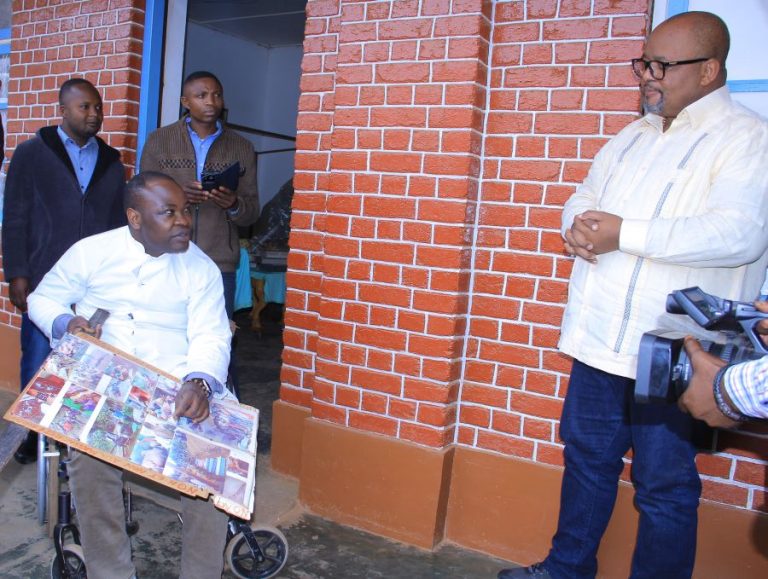 Installé dans sa chaise roulante, l’abbé KANDUKI reçu par le président de l'Assemblée nationale, Aimé Boji.