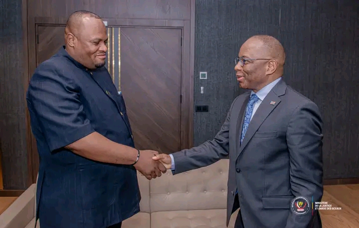 Un poignée de main entre Daniel Bumba, gouverneur de la ville de Kinshasa et Guillaume Ngefa, ministre d'État de la justice.